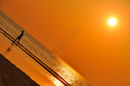 在霍拉海滩日落时行走的人图片