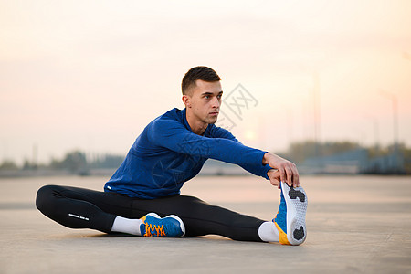 年轻男性赛跑者拉伸并准备在日落 健康的生活方式和体育概念下运行保健卫生天空活动慢跑闲暇男人训练跑步蓝色图片