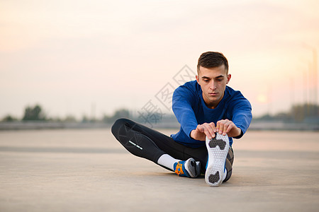 年轻男性赛跑者拉伸并准备在日落 健康的生活方式和体育概念下运行运动蓝色慢跑者闲暇活动训练保健卫生跑步手臂图片