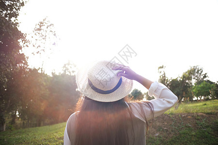 女旅行者戴着帽子 看着森林图片