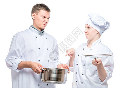 厨师看着一个年轻厨师的烹煮菜盘子图片