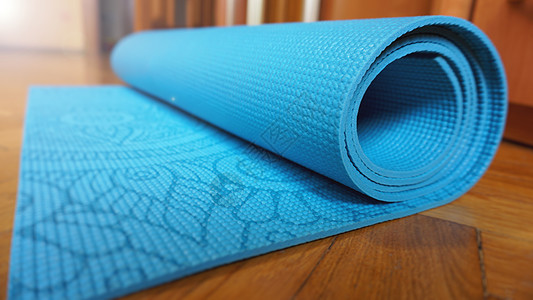 近距离的瑜伽 健身地板垫 在家庭滚动 健康的概念活动闲暇软垫小地毯工作室蓝色宏观橡皮要领地毯图片