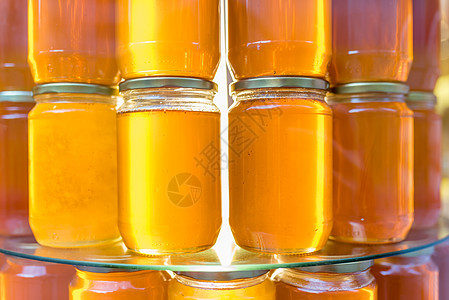 配有自制有机蜂蜜的罐子出售杂货店店铺烹饪市场产品金子玻璃食物黄色棕色图片