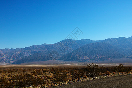 穿过死亡谷国家公园的公路 其背景是帕纳明特山脉Panamint山国家街道死亡山脉沙漠盆地运输日落驾驶地平线图片