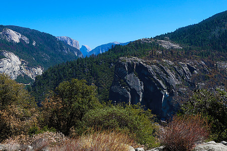 Yosemite 国家公园谷 地道视图日落草地蓝色瀑布船长森林石头国家全景岩石图片