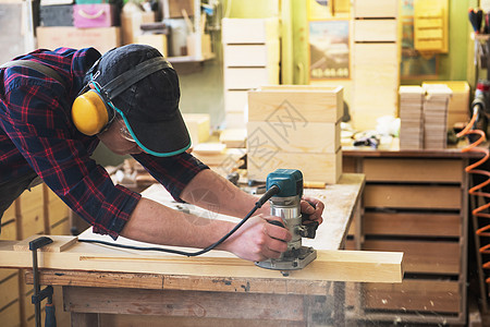 工人研磨木箱木制品男人抛光机材料木工机器木匠家具男性木材背景图片