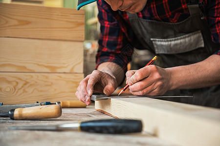 工人对木制板进行测量统治者围裙木匠劳动木头工作建筑师建设者木工木制品背景图片