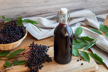 一瓶黑色老黑糖浆加新鲜大莓叶子糖浆自然疗法桌子玻璃药物液体篮子浆果图片