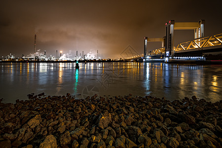 ROTTERDAM 2019年3月21日  在鹿特丹市入口处看到Botlek桥的船对平静水的反射 以化学工业化合物为隔夜天空照明图片