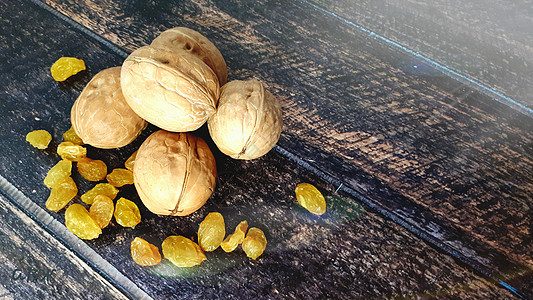 三颗胡桃和一个白岩 躺在木制桌子上营养海报风格水果乡村团体早餐装饰小吃葡萄干图片