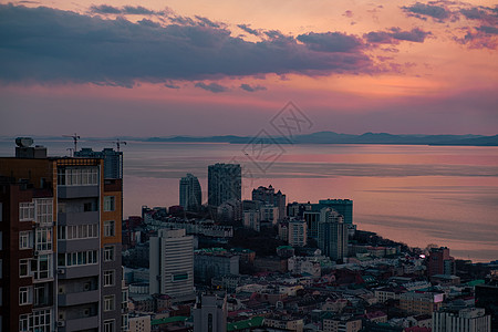 海参沃斯托克市的全景 与日落相对照天际船舶建筑蓝色旅游喇叭港口海浪城市旅行背景