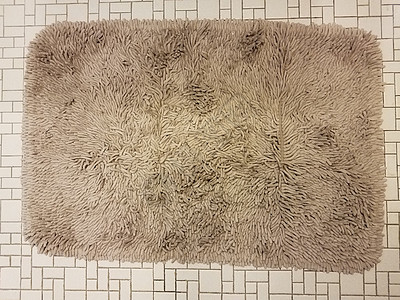 棕色浴室地毯或白色瓷砖地板上的地毯图片