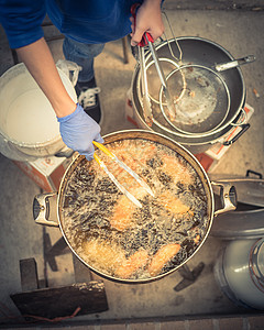 热和燃烧的油罐中深炸米面粉蛋糕平底锅街道小吃市场餐厅烹饪食物面团厨师厨房图片