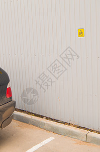 金属围栏上为残疾人小尺寸预留停车标志 为残疾人提供无障碍环境栅栏灰色警告路面服务车轮保姆停车场运输帮助图片