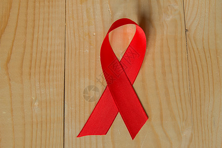 木质背景上的红丝带意识 世界抗击艾滋病日 12 月促进公众支持艾滋病病毒感染者的健康宽容团结缺陷免疫机构网络协会感染治愈癌症图片
