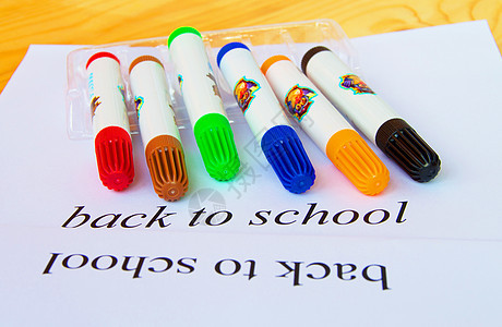 一张纸页 上面有文字和彩色标记 放在木制背景上 有选择性的焦点木头黑板桌子橡皮铅笔蜡笔床单大学笔记标题图片