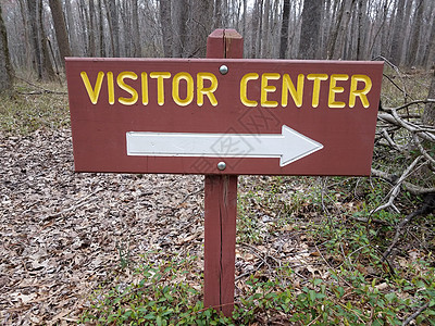 棕红或红红游客中心标志 森林中白右箭和树木图片