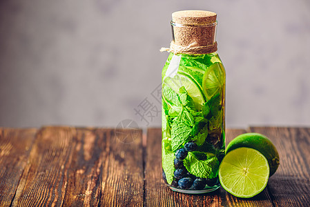 与Lime Mint和Blueberry的脱毒水瓶子水果果汁活力排毒草本植物食物蓝色饮料浆果图片