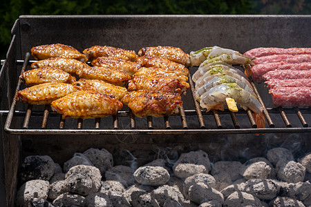 烧烤海鲜在烧烤炉上的热煤上烤烤肉 鸡和虾的混合种类组合火焰对虾木炭太阳广告鸡翅海鲜烹饪腌料煤炭背景