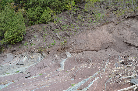 弯曲的灰色和红岩层或山坡上的平层岩石红色地层科学植物地质学石头爬坡背景图片