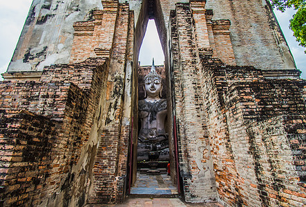 泰国Sukhothai历史公园 在Wat Si Chum寺的古老佛像旅行者佛教徒石头寺庙雕塑冥想游客历史雕像考古学旅游图片