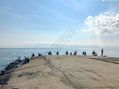 保加利亚Pomorie  2019年7月16日 渔民在海城沿海捕捉新鲜鱼钓竿蓝色海浪晴天太阳闲暇渔夫海滩假期钓鱼图片
