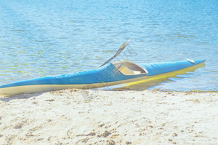 Kayaking概念 Kayak在海滩上 Kayak蓝色和黄色 船在河岸上 夏天阳光明媚的日子 Kayak运动赛艇活力旅行游泳运图片