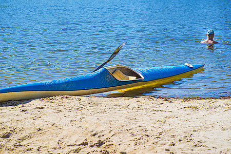 Kayaking概念 Kayak在海滩上 Kayak蓝色和黄色 船在河岸上 夏天阳光明媚的日子 Kayak运动独木舟运动员皮艇爱图片