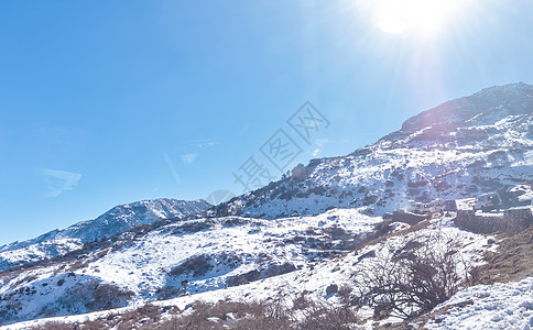 在积雪顶部的太阳覆盖喜马拉雅山脉 在寒冷的冬日 充满深雪的冰冻岩石峰照亮了升起的阳光 湛蓝晴朗的天空 没有云 通往太阳的道路 风图片