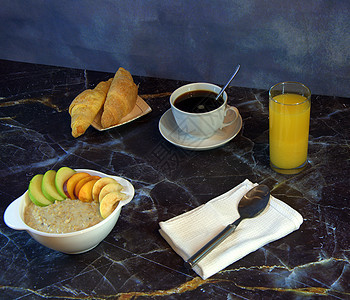 传统的健康早餐 水果燕麦片 一杯黑咖啡 两个羊角面包和一杯橙汁 特写图片