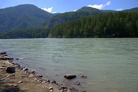 高山背景的宁静河流的岩石岸边 在高山背景下图片