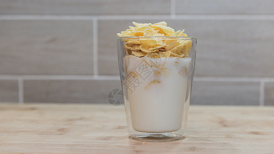 在玻璃杯中装牛奶的玉米片片图片