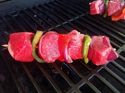 红肉牛肉和青辣椒粘在烧烤上绿色午餐炙烤胡椒洋葱小吃牛肉食物图片