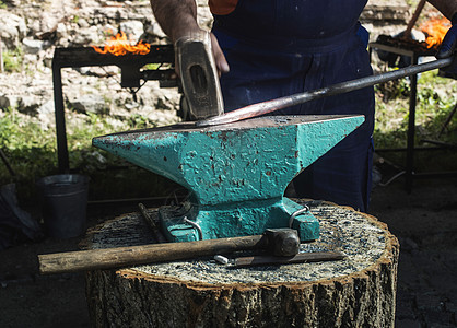 铁匠在铁砧上锻打铁金属工业锤子古董金工工作作坊工具手工红色图片