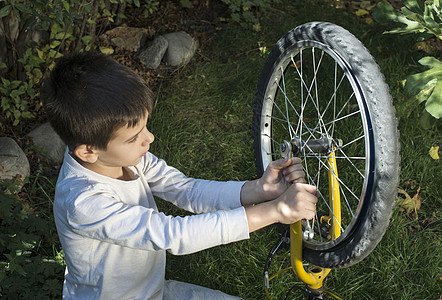 修自行车的孩子维修公园车轮成人服务男性孙子家庭机械男生工具高清图片素材