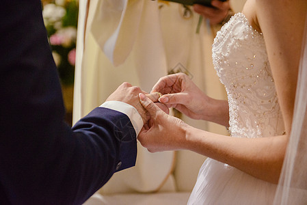 新娘和新郎在婚礼上把结婚戒指戴在手指上生活钻石男人裙子珠宝女士夫妻花束金子婚姻图片