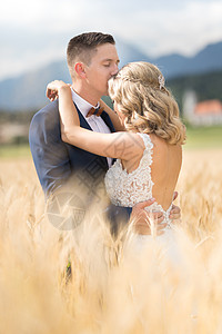 Groom拥抱新娘时 在斯洛文尼亚乡村小麦田某处亲吻她的额头 校对 Soup夫妻微笑女孩夫妇农村婚礼小麦女士奢华领结图片