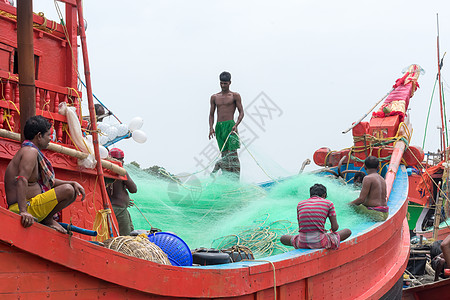 渔民社区准备穿线网系结商业渔网绳索 然后在渔船拖网渔船上投掷渔具捕鱼 印度果阿 2019 年 5 月图片