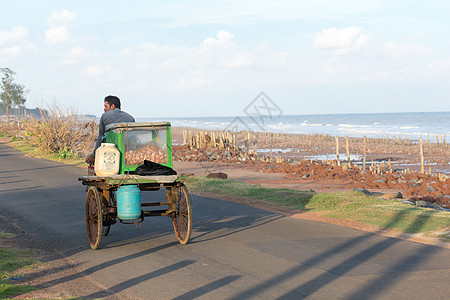 夏日夕阳下 在沿海地区海滩路上 一个农村流动街头食品卖家在传统的人力车上销售 phuchka gol gappa chaat 和图片