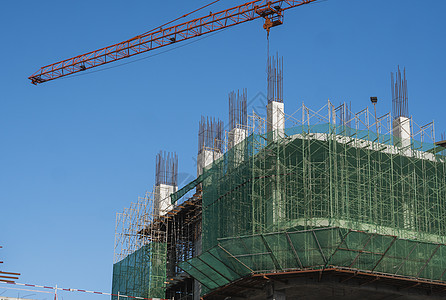 蓝天的起重机和建筑工地 未完工建筑的金属结构施工 塔式起重机用于建造多仓库建筑生长住房商业框架蓝色天空高楼工作技术住宅图片