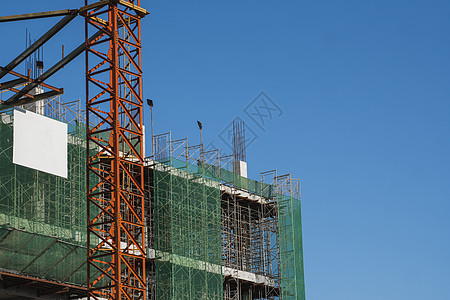 蓝天的起重机和建筑工地 未完工建筑的金属结构施工 塔式起重机用于建造多仓库建筑工程生长天空摩天大楼工作住宅脚手架城市框架建筑学图片