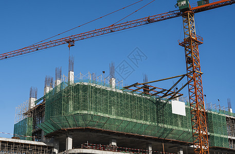 蓝天的起重机和建筑工地 未完工建筑的金属结构施工 塔式起重机用于建造多仓库建筑城市天空公寓水泥住宅摩天大楼机器建筑学工程工作图片