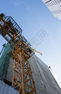 蓝天的起重机和建筑工地 未完工建筑的金属结构施工 塔式起重机用于建造多仓库建筑机器水泥公寓高楼工程项目商业城市工作房子图片