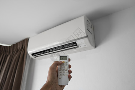 使用遥控器的人的手 手持 rc 和调节安装在白墙上的空调温度 室内舒适温度 健康理念和节能房间技术净化器活力护发素扇子力量加湿器图片