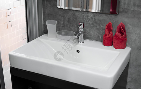 带洗脸盆水槽的现代不锈钢龙头 上面有两条红色毛巾 柜台浴室内部现代 豪华时尚的设计浴室配有混凝土风格的墙壁洗澡建筑学制品盆地卫生图片