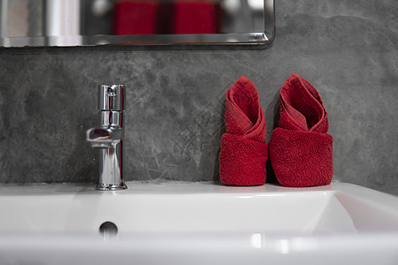 带洗脸盆水槽的现代不锈钢龙头 上面有两条红色毛巾 柜台浴室内部现代 豪华时尚的设计浴室配有混凝土风格的墙壁建筑学奢华房子财产镜子图片