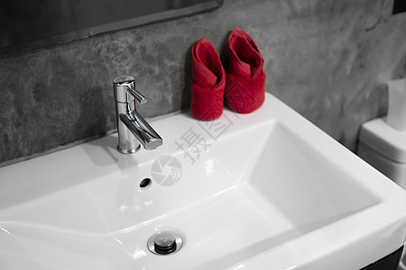 带洗脸盆水槽的现代不锈钢龙头 上面有两条红色毛巾 柜台浴室内部现代 豪华时尚的设计浴室配有混凝土风格的墙壁建筑学洗澡卫生合金镜子图片