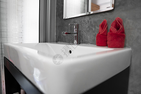 带洗脸盆水槽的现代不锈钢龙头 上面有两条红色毛巾 柜台浴室内部现代 豪华时尚的设计浴室配有混凝土风格的墙壁金属卫生间家具公寓洗手图片