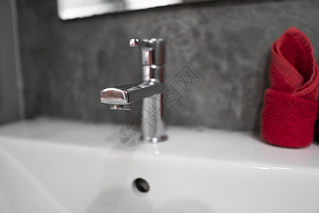 带洗脸盆水槽的现代不锈钢龙头 上面有两条红色毛巾 柜台浴室内部现代 豪华时尚的设计浴室配有混凝土风格的墙壁房子卫生肥皂房间建筑学图片