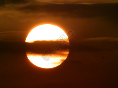 与太阳和重叠的云的日落 春天的场景 太阳躲在黄昏天空中的云层中 阴云密布的漂浮云景部分遮挡了阳光 春天的日落 美丽的太阳能 自然图片